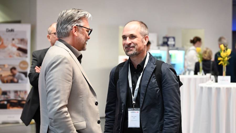 Zwei Männer unterhalten sich bei Networking-Event und tragen Namensschilder